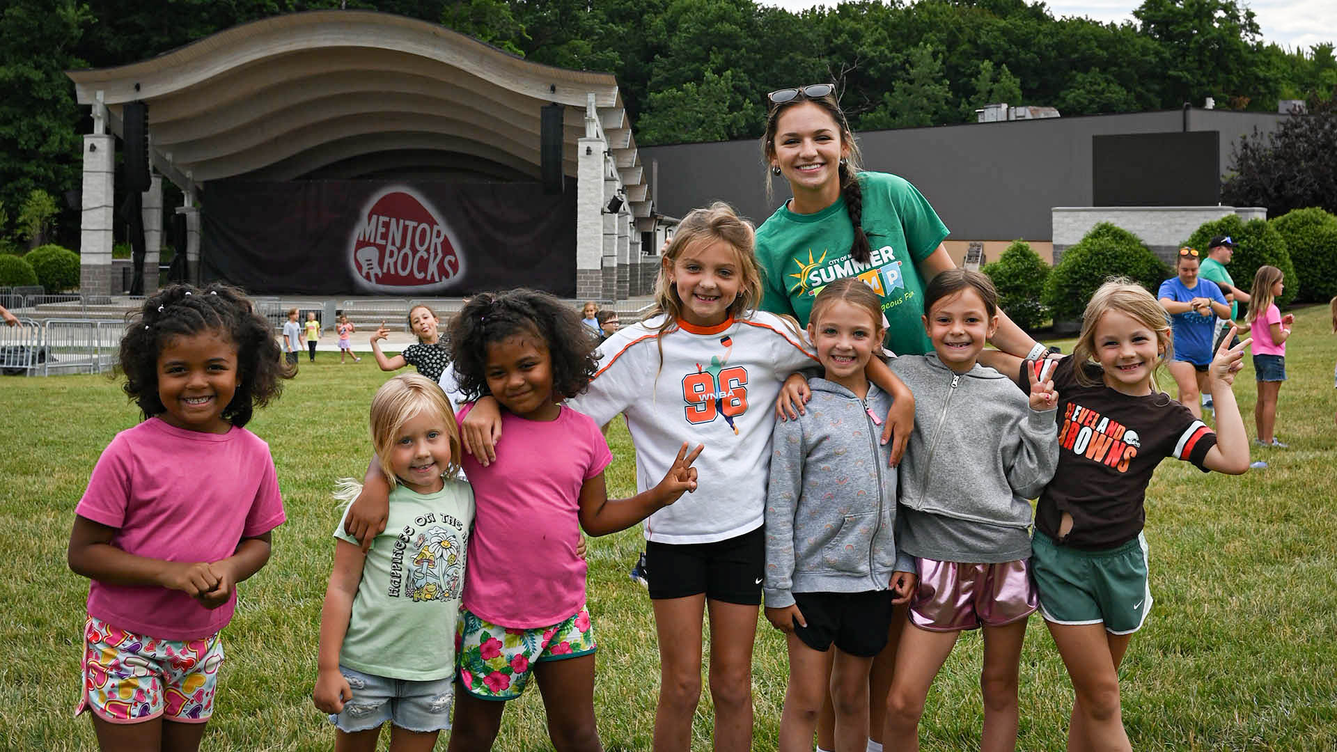 An image of summer day camp participants at Mentor Civic Center Park with the Amphitheater in the background.