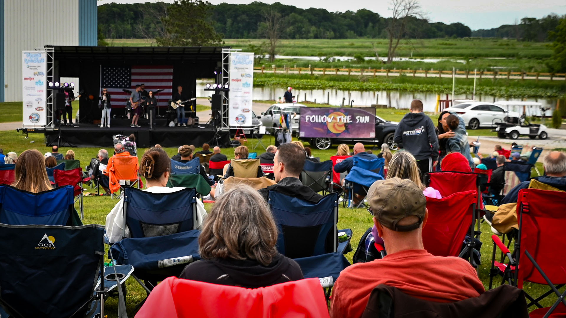 A crowd of people watching a concert at the Tunes at the Lagoons concert series.