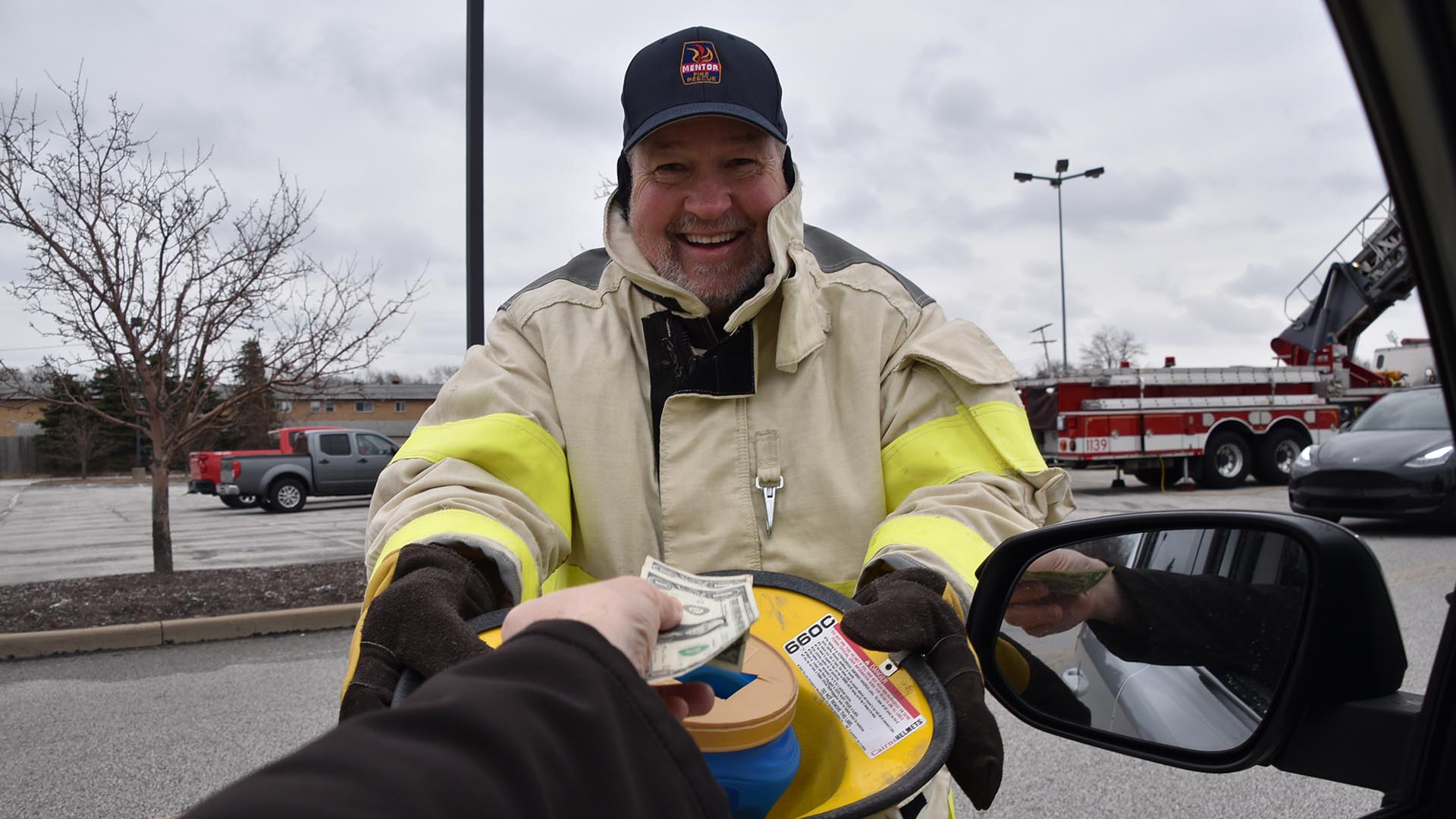 Mentor Firefighter Accepting Donation at Rescue the Needy Food Drive 2022.