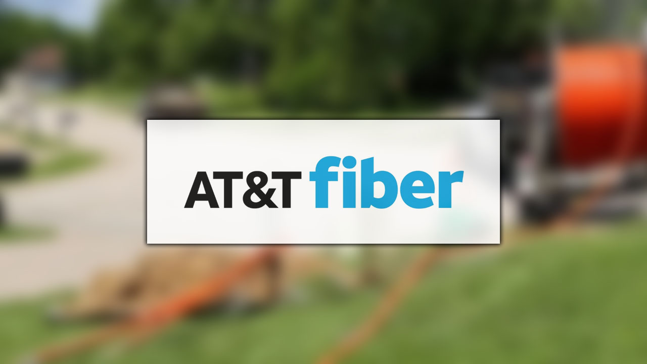 A blurred image of fiber lines being installed with the AT&T fiber logo superimposed on a white field. 