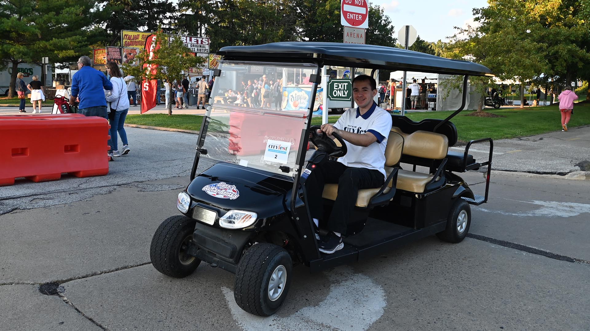 An image of aMentor CityFest volunteer sitting in a golf cart